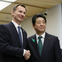 Jeremy Hunt, British Secretary of State for Foreign and Commonwealth Affairs, greets Prime Minister Shinzo Abe during a courtesy call at Abe\'s office in Tokyo on Monday. | AP