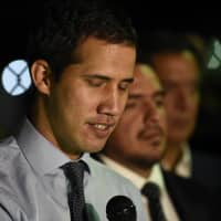 Juan Guaido, president of the National Assembly who swore himself in as the leader of Venezuela, speaks to members of the media outside his home in Caracas on Tuesday. | BLOOMBERG