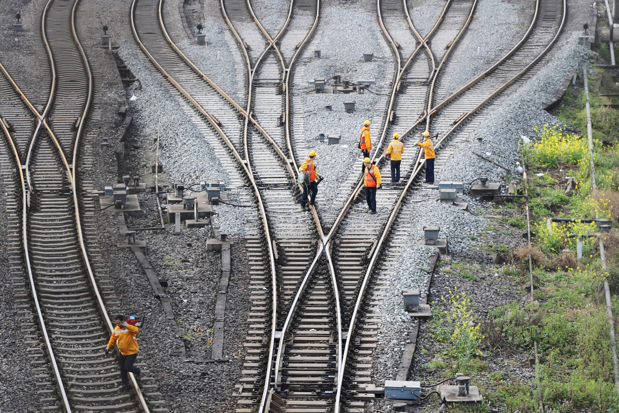 Workers inspect railway tracks that serve as a part of the 'Belt and Road' freight rail route linking Chongqing, China, to Duisburg, Germany, at the Dazhou railway station in Sichuan province, China, on March 14. | REUTERS