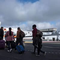 Asylum seekers walk at El Chaparral port of entry to present themselves to U.S. border authorities to request asylum, in Tijuana, Baja California state, Mexico, on Tuesday. A U.S. federal judge on Monday blocked President Donald Trump\'s policy of returning asylum seekers to Mexico to wait out the processing of their cases, saying the Department of Homeland Security had overstepped its authority. | AFP-JIJI