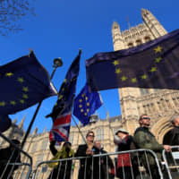 Protesters against Brexit hold EU flags outside the Houses of Parliament on Thursday. | REUTERS