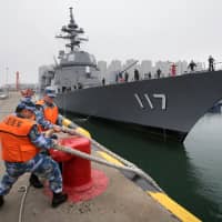Chinese Navy soldiers moor the Maritime Self-Defense Force destroyer Suzutsuki at Qingdao Port for the 70th anniversary celebrations of the founding of the Chinese People\'s Liberation Army Navy in the city on Sunday. | REUTERS