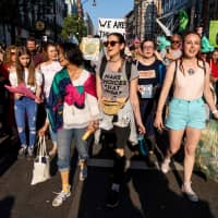 Climate change activists walk near Oxford Circus in London on Saturday. | AFP-JIJI