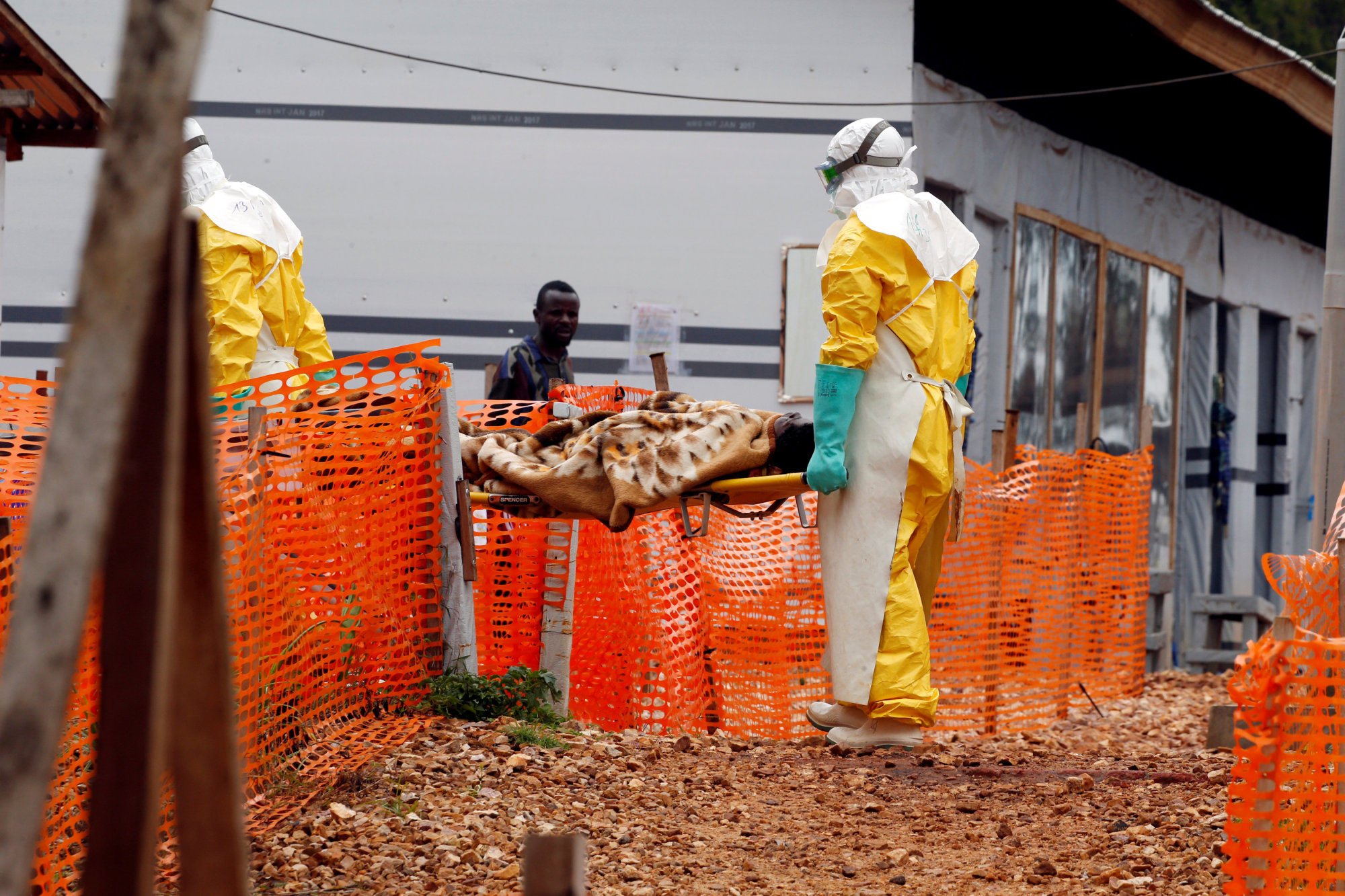 Health workers carry a newly admitted confirmed Ebola patient into a treatment center in Butembo in the eastern Democratic Republic of Congo, March 28. | REUTERS