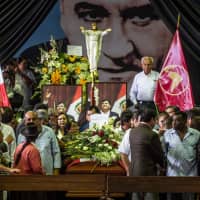 Supporters of the late Peruvian ex-President Alan Garcia pay respects during his wake at the American Popular Revolutionary Alliance (APRA) party headquarters in Lima Thursday. | AFP-JIJI