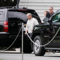 Sen. Lindsey Graham (R-SC) walks to a vehicle carrying U.S. President Donald Trump before departing the White House in Washington Sunday. | REUTERS
