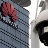 A surveillance camera is seen in front of the Huawei logo outside its factory campus in Dongguan, in China\'s Guangdong province,  on March 25. | REUTERS