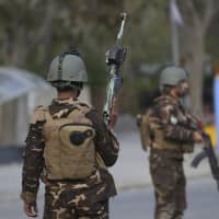 Afghan security personnel arrive outside the Telecommunication Ministry during a gunfight with insurgents in Kabul Saturday. A suicide blast rocked Afghanistan\'s capital Saturday during a gun battle with security forces, officials said, killing several people a day after hopes for all-encompassing peace talks collapsed. | AP