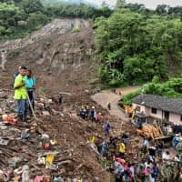 People search for victims after a landslide in Rosas, Valle del Cauca department, in southwestern Colombia, on Sunday. At least 14 people were killed and five others injured by a mudslide that buried eight houses early Sunday in southwestern Colombia, authorities said. | AFP-JIJI