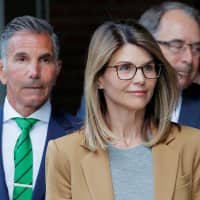 Actor Lori Loughlin and her husband, fashion designer Mossimo Giannulli, leave the federal courthouse after facing charges in a nationwide college admissions cheating scheme, in Boston April 3. | REUTERS