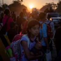 A migrant girl traveling with a caravan of thousands from Central America en route to the U.S. holds her belongings while making her way to Mapastepec from Huixtla, Mexico, last year. | REUTERS