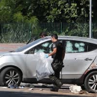 A police officer collects a gun at the scene where policemen faced a gang after attempting an armed bank robbery in Guararema, near Sao Paulo Thursday. | REUTERS