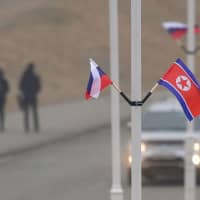 Flags of Russia and North Korea are seen fixed on lamp posts on Russky island in the far-eastern Russian port of Vladivostok on Tuesday. North Korean leader Kim Jong Un will visit Russia for his first summit with President Vladimir Putin on Thursday, a Kremlin aide said. | AFP-JIJI