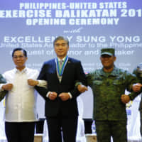 Philippine Armed Forces Southern Luzon Command Chief Lt. Gen. Gilbert Gapay (from left), Undersecretary of National Defense Cardozo Luna, U.S. Ambassador to the Philippines Sung Kim, Armed Forces of the Philippines Chief Gen. Benjamin Madrigal Jr. and Brig. Gen. Christopher McPhillips link arms during the opening ceremony of the joint U.S.-Philippine military exercise Balikatan 2019 on Monday at Camp Aguinaldo, northeast of Manila. | AP