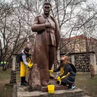 Volunteers clean a monument representing Soviet leader Josef Stalin during a spring community work day at the Muzeon Park of Arts in Moscow on Saturday. | AFP-JIJI