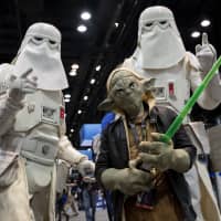 Fans dressed as characters pose for a photograph during the Star Wars Celebration event at McCormick Place convention center in Chicago on Friday. Walt Disney Co. released a trailer and the name for its latest Star Wars film, \"Star Wars: The Rise of Skywalker.\" It\'s the fifth Star Wars movie that Disney has released since acquiring Lucasfilm Ltd. for &#36;4 billion in 2012. | BLOOMBERG