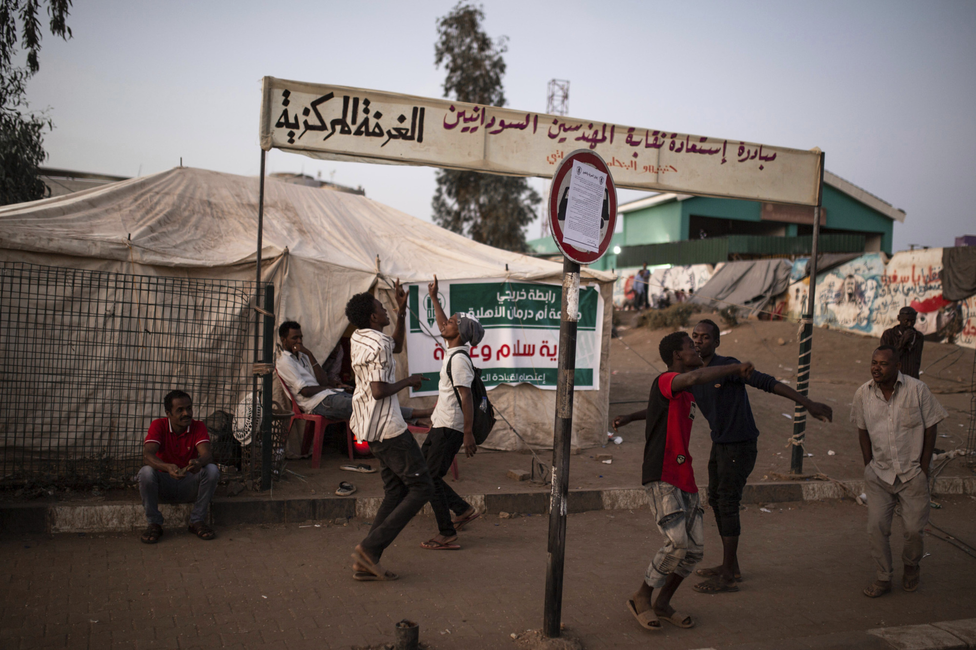 Protesters demanding civilian rule dance at a sit-in outside the military headquarters in Khartoum on Saturday. | AP