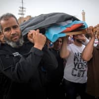 Libyans carry the body of a fighter loyal to the Government of National Accord (GNA) during his funeral in Tripoli on Wednesday after he was reportedly killed during clashes with forces loyal to strongman Khalifa Haftar in al-Hira region, about 70 km south of Tripoli. | AFP-JIJI