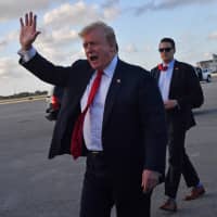 U.S. President Donald Trump waves upon arriving at Palm Beach International Airport in Florida on Thursday. | AFP-JIJI