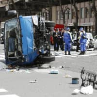 Police investigate an accident Friday in which a car struck pedestrians and a garbage truck in the Ikebukuro district of Tokyo, leaving 10 people injured, two of them in critical condition. | KYODO