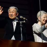 Emperor Akihito and Empress Michiko wave to well-wishers during a public appearance for New Year\'s celebrations at the Imperial Palace in Tokyo on Jan. 2. | REUTERS