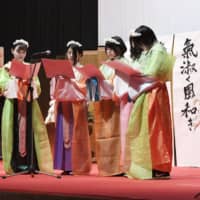 Students at Japan University of Economics in Dazaifu, Fukuoka Prefecture, read poems from “Manyoshu” as they re-create an ancient plum blossom viewing party on Saturday. | KYODO