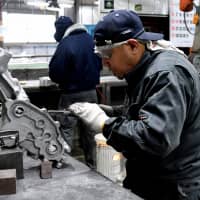 Dexter Tan Dimaapia, an employee from the Philippines at Sakae Casting Co., works at the firm\'s aluminum-casting plant in Hachioji, western Tokyo, on Jan. 29. | YOSHIAKI MIURA