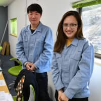 Parnward Manakul (right), a Thai employee at Atom Co., and Son Seung-hyeon, an intern from South Korea, pose for a photo at their office in Tokyo’s Hachioji on Jan. 29.  | Yoshiaki Miura