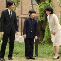 Prince Hisahito prepares to pose for a photo with his parents, Prince Akishino and Princess Kiko, before attending the entrance ceremony for a junior high school affiliated with Ochanomizu University in Tokyo\'s Bunkyo Ward on Monday. | POOL / VIA KYODO