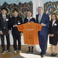 International Olympic Committee President Thomas Bach and teenage \"reconstruction ambassadors\" from the Tohoku region pose for photos on Monday in Lausanne, Switzerland. | KYODO