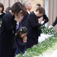 People offer flowers and prayers Sunday at the Kumamoto Prefectural Government office in the city of Kumamoto, where a ceremony was held to commemorate the victims of a series of powerful earthquakes that shook the area three years ago. | KYODO