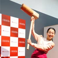 Retired figure skater Mao Asada poses for photos as she prepares to pound steamed rice to make rice cake during an event in Kyoto on Jan. 4, 2018 | KYODO