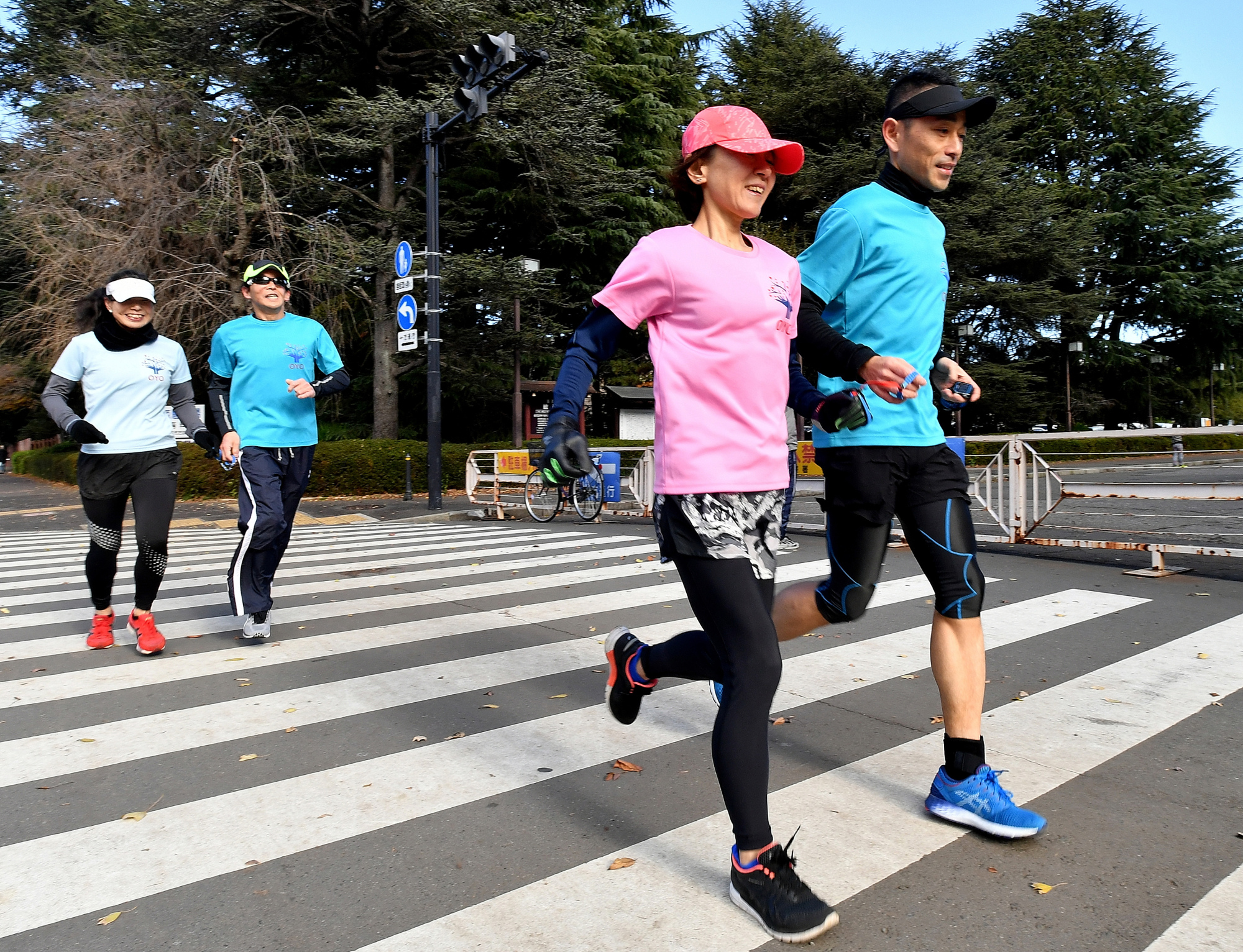 Blind marathon runner Yoko Aoki (front left) practices with Yasuhiro Ukitsu guiding her at Jingu Gaien in Tokyo on Dec. 24. | YOSHIAKI MIURA