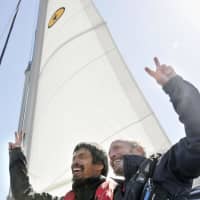 Blind sailor Mitsuhiro Iwamoto and his navigator, Doug Smith, react on Saturday in Iwaki, Fukushima Prefecture, after they successfully completed a nonstop voyage from San Diego. | KYODO