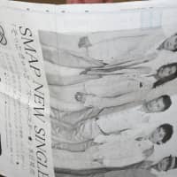 A man reads a four-page newspaper ad for SMAP in Tokyo in August 2009. | BLOOMBERG