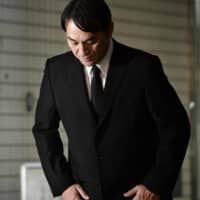 Pierre Taki bows in apology in front of a police station in Tokyo on Thursday after he was released on bail. | KYODO