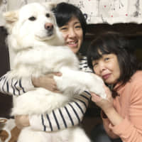 Fit for a king: Kana Komatsu holds Wenceslas while sitting next to her mother at home in Kyoto. | KAYO KOMATSU