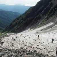 Gear up: Hikers take the exciting approach to the summit of Mount Shirouma via the Daisekkei (Great Snow Valley), a year-round snow field for which simple crampons are recommended. | TOM FAY