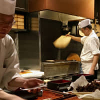 Fanning the flames: Chefs prepare unagi (eel) over a charcoal grill at Kurocyodo in Roppongi Hills. | ROBBIE SWINNERTON