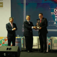 Khalid Abdul Hamid, director of the Ministry of Economic Affairs\' Service Industry Section, presents one of  several Halal Excellence Awards that honor various groups\' achievements. | WHC