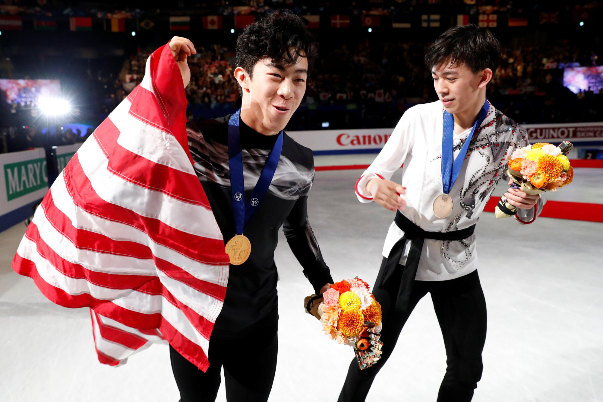 Winner Nathan Chen (left) and third-place finisher Vincent Zhou celebrate with their medals following the men's competition at the World Championships on March 23 in Saitama. The two skaters will represent the United States in the World Team Trophy, which begins on Thursday in Fukuoka. | REUTERS