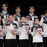 Team Japan\'s skaters are seen with their silver medals during the awards ceremony on Saturday. Front row (from left): Misato Komatsubara, Kaori Sakamoto, Rika Kihira and Riku Miura. Back row (from left): Tim Koleto, Shoya Ichihashi, Keiji Tanaka and Shoma Uno. | AP