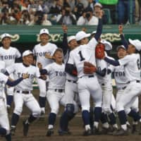 The Toho team surrounds pitcher Takaya Ishikawa (1) on the mound as they celebrate their win over Narashino in the National High School Baseball Invitational Tournament final on Wednesday at Koshien Stadium. | KYODO