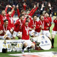 Urawa Reds players celebrate after winning last year\'s Emperor\'s Cup at Saitama Stadium on Dec. 9, 2018. Three fans who lit flares outside the stadium were charged with violations of the Road Safety Act on Monday. | KYODO
