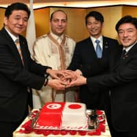 Tunisian Ambassador Mohamed Elloumi (second from left) joins (from left) Japan-Tunisia Parliamentary Committee Chairman Nobuo Kishi; Parliamentary Vice-Minister for Foreign Affairs Kenji Yamada; and Japan-Tunisia Parliamentary Committee Director General Yasuhide Nakayama during a cake-cutting ceremony to celebrate Tunisia\'s 63rd national day at the ambassador\'s residence in Tokyo on March 20. | YOSHIAKI MIURA