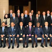 Foreign Minister Taro Kono (front row, center) joins the Dean of the Council of Arab Ambassadors in Japan and Palestinian Ambassador Waleed Siam (third from left), President and Djiboutian Ambassador Ahmed Araita Ali (third from right) and others at a dinner hosted by the Council of Arab Ambassadors in Japan at the Shangri-La Hotel, Tokyo on March 18. | MIKI OSHITA
