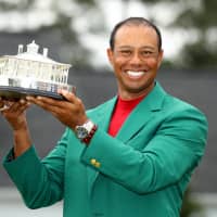 Tiger Woods celebrates with his green jacket and trophy after winning the 2019 Masters on Sunday at Augusta National Golf Club in Augusta, Georgia. It was Woods\' first major title in nearly 11 years and 15th overall, three short of Jack Nicklaus\' record of 18. | REUTERS