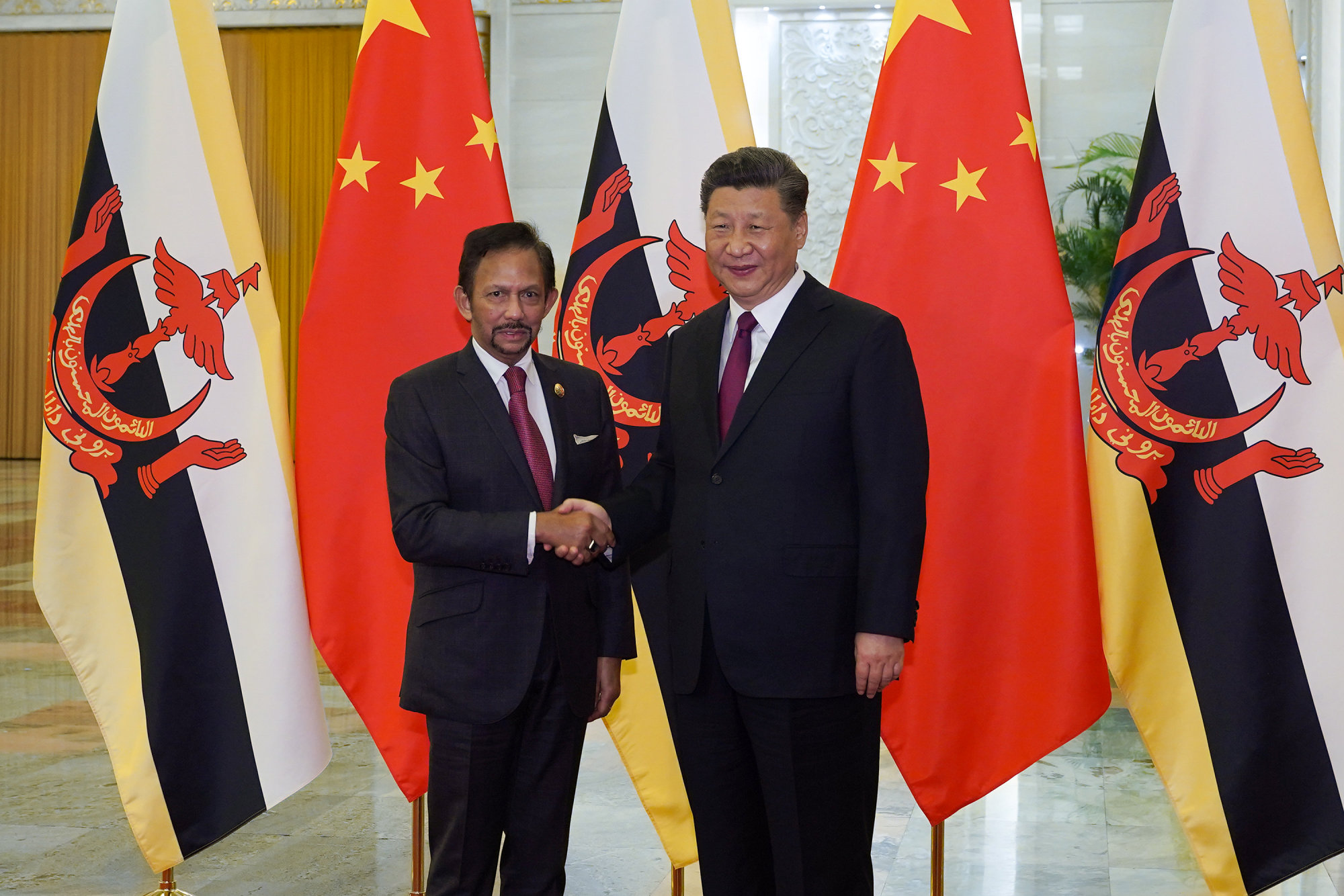 Chinese President Xi Jinping (right) shakes hands with Brunei Sultan Hassanal Bolkiah before the bilateral meeting of the Second Belt and Road Forum at the Great Hall of the People on April 26 in Beijing. | REUTERS