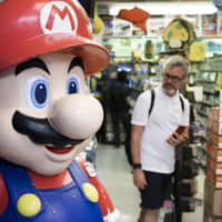 A statue of the Nintendo Co. video-game character Mario stands on display in the Akihabara district of Tokyo. | BLOOMBERG
