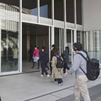 People walk into Nissan Motor Co.\'s headquarters in Yokohama last month. | KYODO